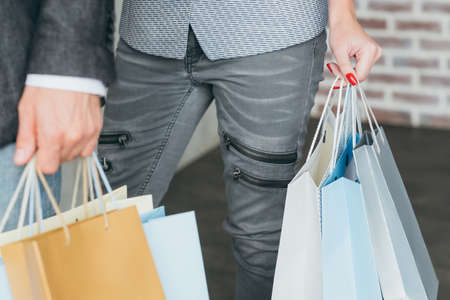 shopaholics and spending lifestyle. cropped shot of man and woman with multiple bags in hands.の写真素材
