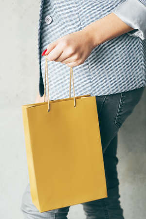 brown paper bag in woman hand. consumerism and shopping concept.の写真素材