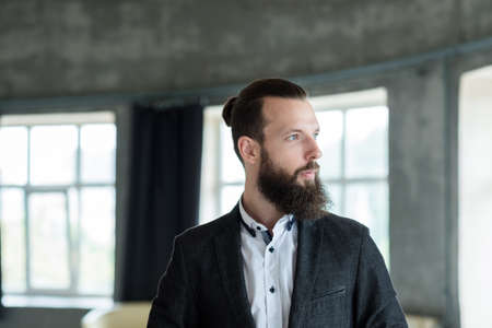 business man portrait. stylish handsome bearded male in modern office space.の写真素材
