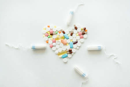 menstrual cramps medication. mix of pills and tampons on white background.の写真素材