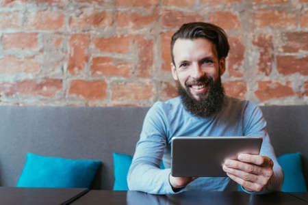 mobile devices addiction. man holding tablet. social networks and idle leisure conceptの写真素材