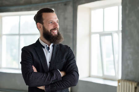 smiling business man with arms crossed. office dress code and stylish corporate look.の写真素材