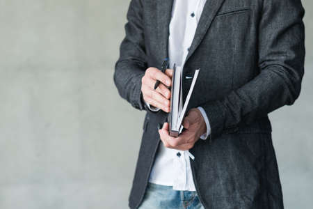 man hand opening in notepad. agenda or scheduled control of business affairs.の写真素材