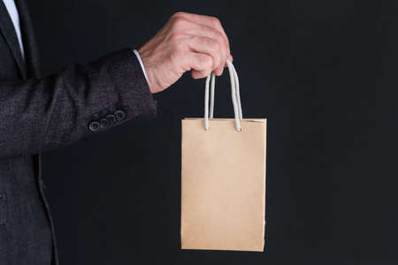 brown paper bag in man hand. shopping and consumerism concept.の写真素材