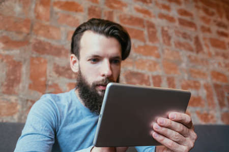 focused man reading on tablet. education knowledge and access to informationの写真素材