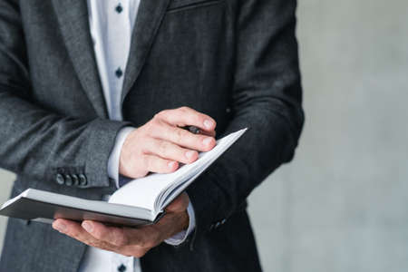 business coach and career training. man holding notebook and pen.の写真素材