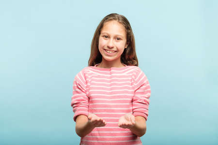 smiling cute girl holding virtual object in hands. empty space for advertisement or product placement.の写真素材