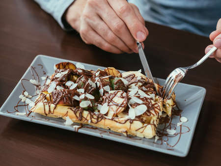 man hands cutting belgian waffle. food and sweet delicacy.の写真素材