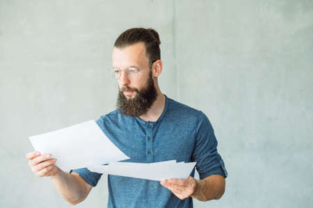focused man reading or studying business documents. information analysis and paperworkの写真素材