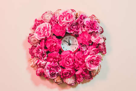 Conceptual art. Flower composition with clock. Floral decor element on ivory background.の写真素材