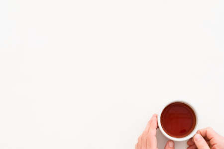 Hands holding cup of tea. Coziness concept. Copy space on white background.の写真素材