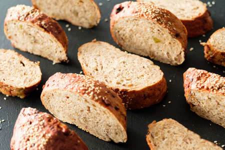 Home made bakery. Pattern composition. Wholegrain bread slices on black background.の写真素材