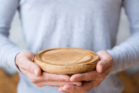 Nature protection concept. Wooden tray mockup in man hands. Free space for advertising.の写真素材