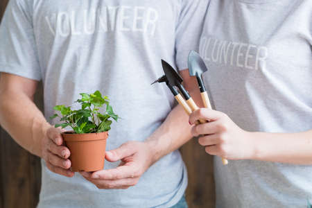 Planting volunteers. Nature care and protection. Couple with houseplant and garden tools.の写真素材