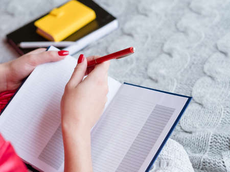 New day planning. Chores and shopping. Woman making notes in empty notebook.