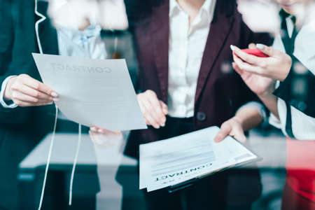 Business matters. Women colleagues communication. Contract issues and office paperwork discussion.