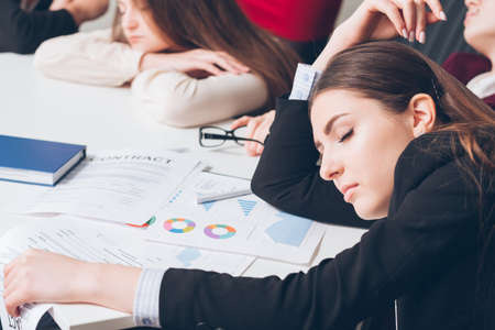 Tired corporate managers. Overworking concept. Business team members sleeping on desk.