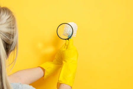 Cleaning company. Professional home office cleanup. Woman in rubber gloves magnifying brush. Copy...