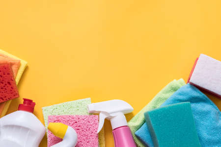 Careful housekeeping. Organized housewife. Cleaning supplies assortment beneath yellow copy space.の写真素材