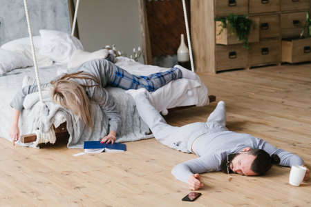 No night sleep. Exhausted workaholic couple fell asleep chaotically.の写真素材