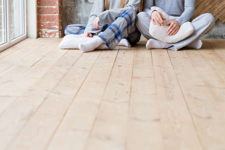 Restless night. Internet addiction. Couple with pillows sitting on floor.の写真素材