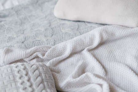 Knitted blankets assortment. Handmade textile craft. Crumpled texture background.