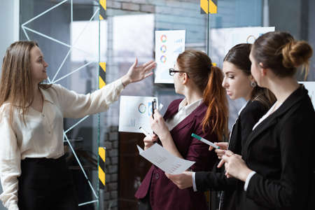 Business meeting. Successful corporate strategy presentation. Female speaker pointing at annual corporate statisticsの写真素材