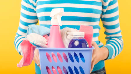 Cleaning company. Professional home cleanup. Woman with basket of supplies.の写真素材