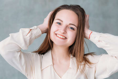 Smiling young woman portrait. Happiness. Attractive content female touching head.の写真素材