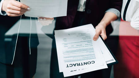 Big contract discussion. Corporate law team cooperation. Young business women examining agreement.の写真素材
