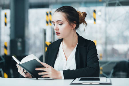Woman at work. Corporate workplace. Business executive checking schedule in day planner.の写真素材