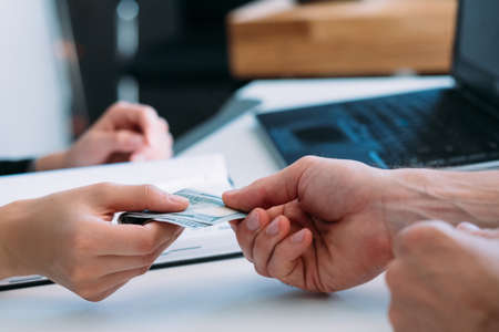 Business workplace. Corporate corruption. Man offering dollar bills bribe. Company employee...