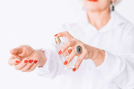 Senior female elegance. Fashion perfume trends. Stylish elderly lady applying expensive fragrance.の写真素材