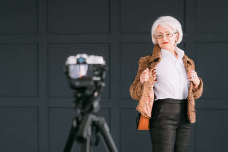 Senior woman style. Confidence and elegance. Aged model posing during studio photo shooting.の写真素材