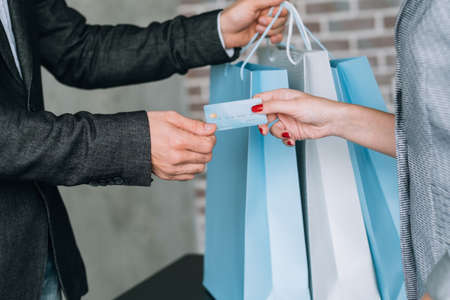 Urban shopping lifestyle. Credit card payment. Woman with plastic money at checkout.の写真素材