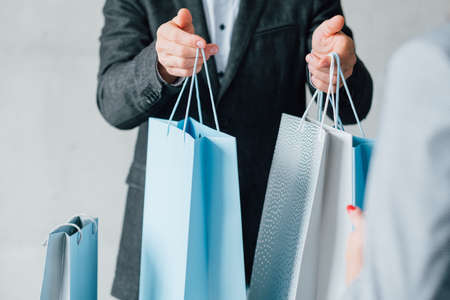 Man shopping. Season sale consumerism. Paper bags variety for woman.