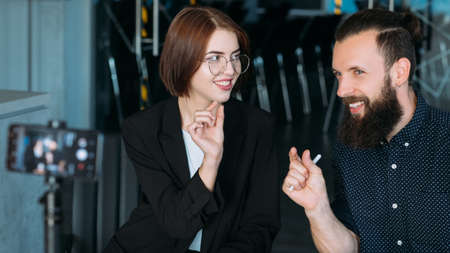 Business workshop. Leadership coaching. Man and woman shooting master class. Mobile video.の写真素材