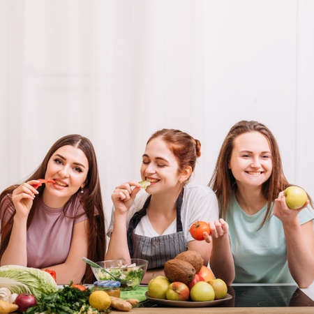 Healthy nutrition and diet food. Vegetarian cooking and weightloss. Young women snacking on veggies and saladの写真素材