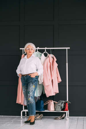 Senior fashion trends. Personal style. Confident elderly woman demonstrating wardrobe. Copy space.の写真素材