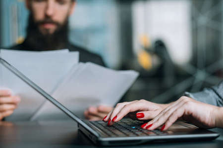 Coworking. Business matters discussion. Office workplace. Female hands typing on laptop.の写真素材