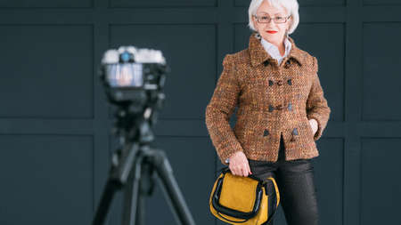 Successful senior woman. Fashion coach. Blogging lifestyle. Elderly lady posing for mobile video.の写真素材