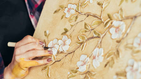Creating floral pattern artwork. Artist talent and imagination. Woman painter with modeling tool. Canvas on easel.の写真素材