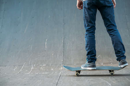 Urban skater. Leisure and lifestyle. Man on skateboard. Guy in jeans backview. Cropped shot. Skate park ramp. Copy space.の写真素材