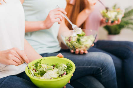 Clean eating. Organic recipe. Healthy whole food nutrition. Green salad bowls in female hands.の写真素材