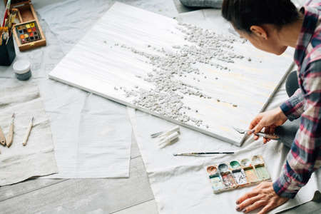 Artist at work. Creative atmosphere. Lifestyle habits. Woman with textured painting, paints and...