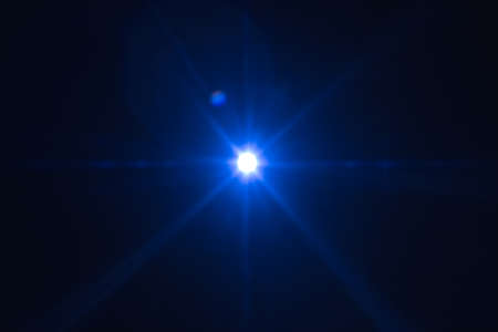 Single blue spark on black background. Lens flare effect. Defocused rays and lights.の写真素材