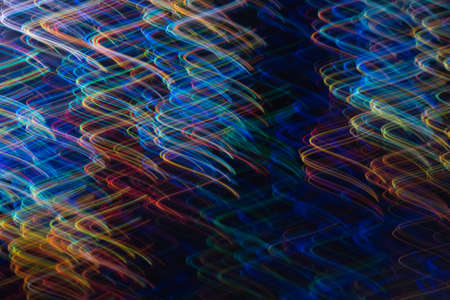 Blurred neon multicolor glow on dark background. Lens flare effect. Night city lights.