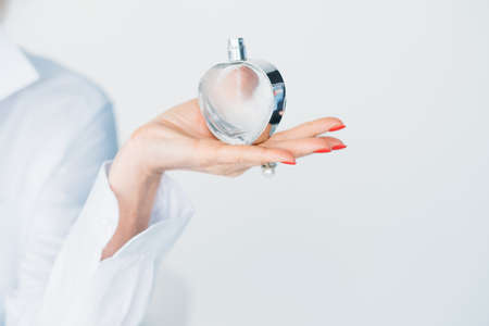 Expensive perfume in woman hand. Elegance and fragrance. Consultant advice on trendy scent. Beauty...