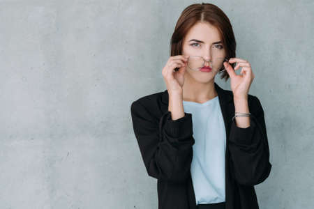 Successful career. Business woman standing with confident facial expression, removing eye glasses. Lady holding senior positions.の写真素材