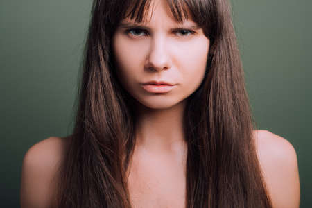 Contemptuous looking beautiful girl. Wary facial expression. Closeup portrait of emotional lady.の写真素材